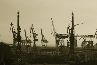 Cranes at construction site against clear sky