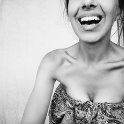 Close-up portrait of smiling young woman against white background