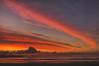 Scenic view of sea against dramatic sky during sunset