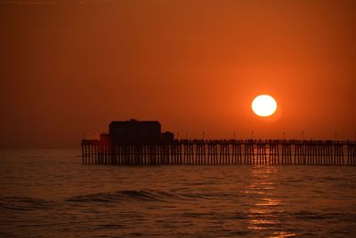 Pier on sea at sunset