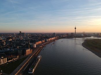 High angle view of river amidst buildings against sky during sunset