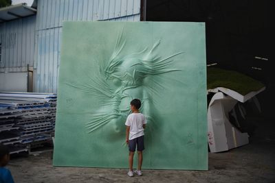 Rear view of man and woman standing against graffiti