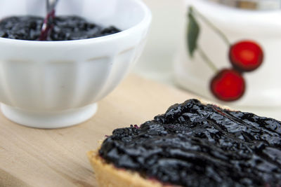 Close-up of preserves with bread on wooden tray