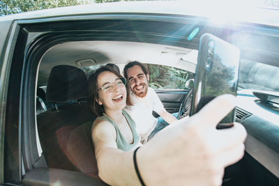 Couple taking selfie in car