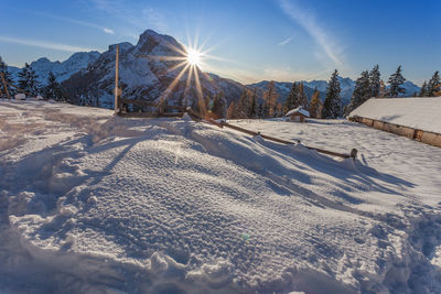 Sunset on alpine hut in front of a beautiful winter scenery, val fiorentina, dolomites, italy