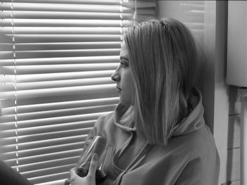 Woman looking though window at home