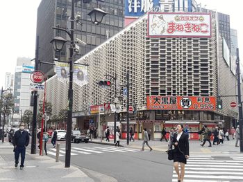 People walking on road by building