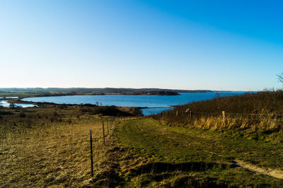 Scenic view of calm sea against clear blue sky
