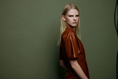 Young woman standing against wall