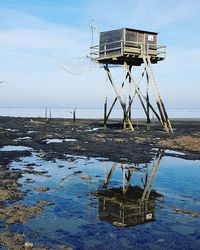 Lifeguard hut by sea against sky