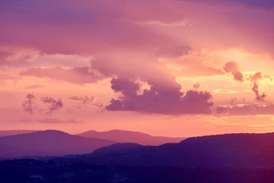 Scenic view of silhouette mountains against romantic sky