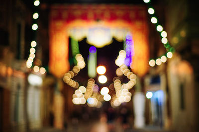 Close-up of illuminated lighting equipment hanging at night