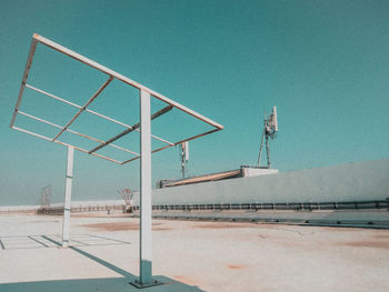 Wind turbines by road against clear sky