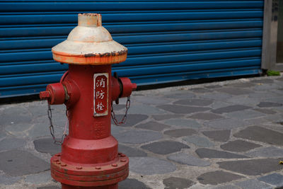 Fire hydrant on sidewalk against wall