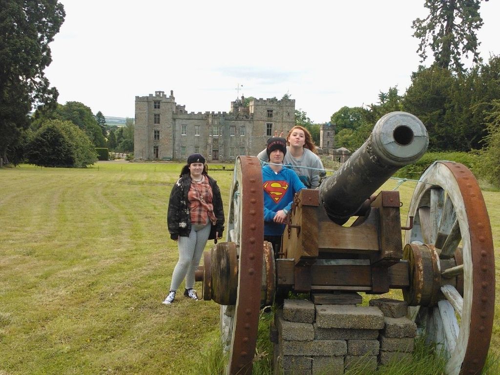 lifestyles, building exterior, leisure activity, built structure, architecture, casual clothing, men, grass, full length, sky, land vehicle, day, field, togetherness, standing, clear sky, young men