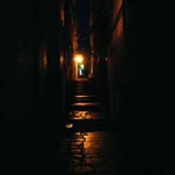 Empty narrow alley along old town at night