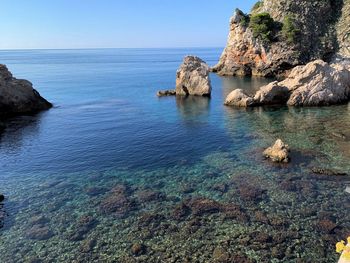 Rock formation in sea against sky