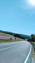 Road amidst landscape against blue sky