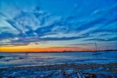 Scenic view of sea against dramatic sky during sunset