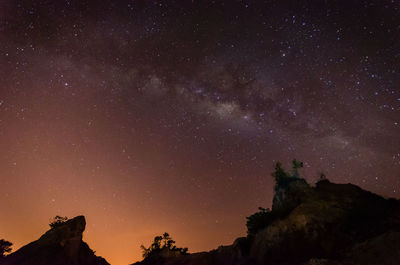 Low angle view of silhouette mountain against sky at night