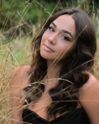 Portrait of a young brunette woman, with brown eyes, long hair, in a autumn natural background.