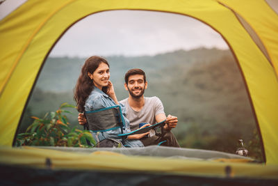 Portrait of young couple camping outdoors