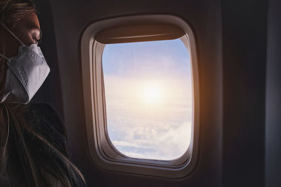 Rear view of woman looking through window