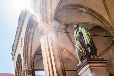 Low angle view of statues on building against sky