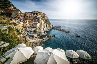 High angle view of buildings by sea against sky