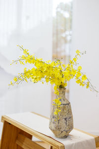 Close-up of yellow flower vase on table