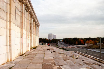 Empty street amidst buildings in city against sky