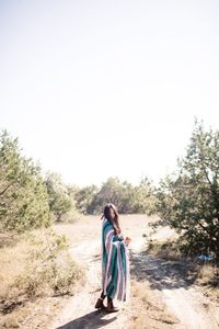 Side view of woman standing against clear sky