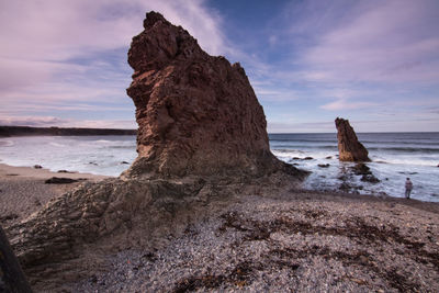 Headlands in calm sea against the sky