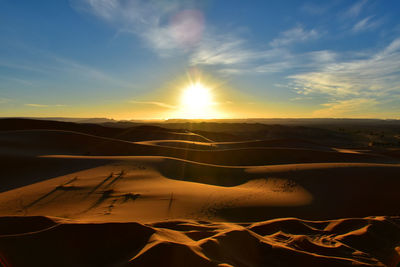 Scenic view of desert against sky during sunset