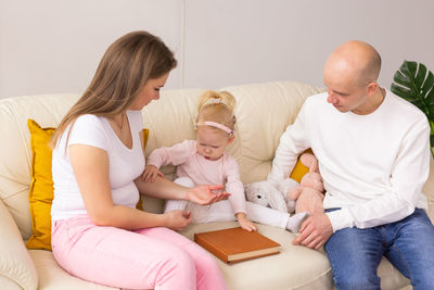 Happy family sitting on sofa at home