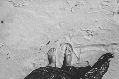 Low section of person standing on sand