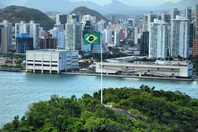 Brazilian flag by river in city