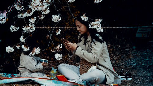 Rear view of women sitting on plant