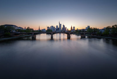 View of buildings by river against sky during sunset in frankfurt am main, germany