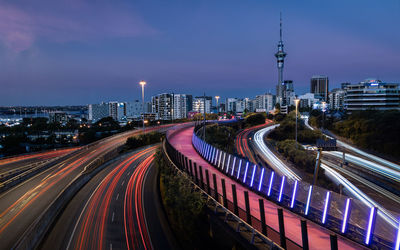 High angle view of light trails on road amidst buildings in city