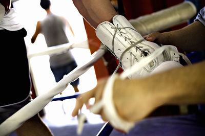 Midsection of boxer with friend wearing boxing glove