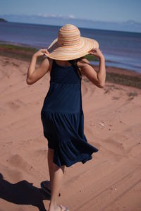 Rear view of woman wearing straw hat at beach