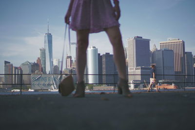 Man standing by buildings in city against sky