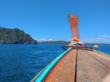 Ship sailing in sea against clear blue sky