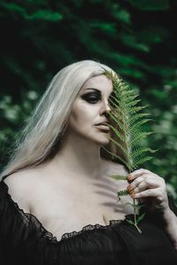 Close-up of young woman holding plant