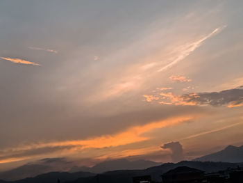 Low angle view of silhouette mountains against dramatic sky