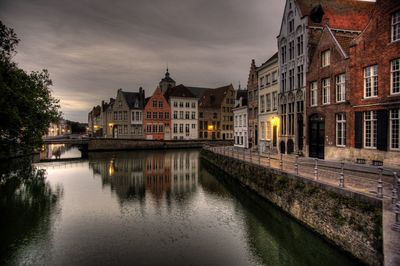 Canal amidst buildings against sky in city