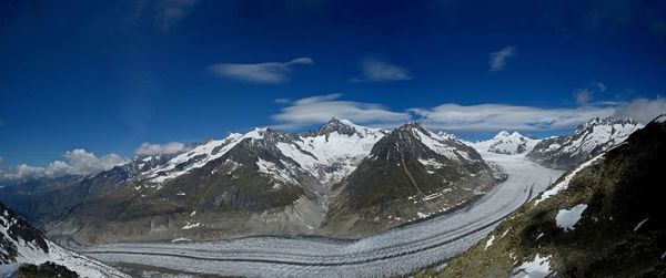 Panoramic view of snowcapped mountains against blue sky