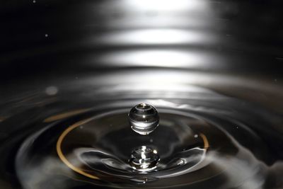 Close-up of drop falling on water