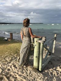 Rear view of woman standing on beach